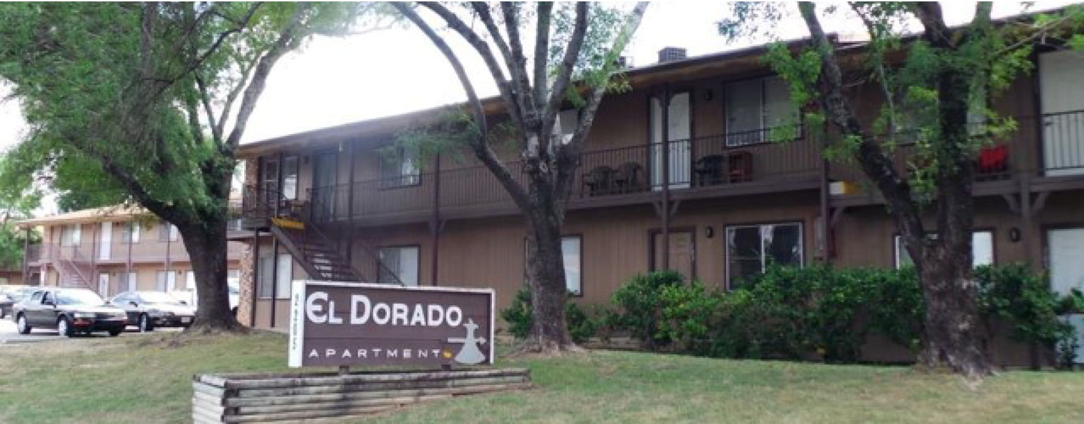 The frontside view of El Dorado Apartments with signage.
