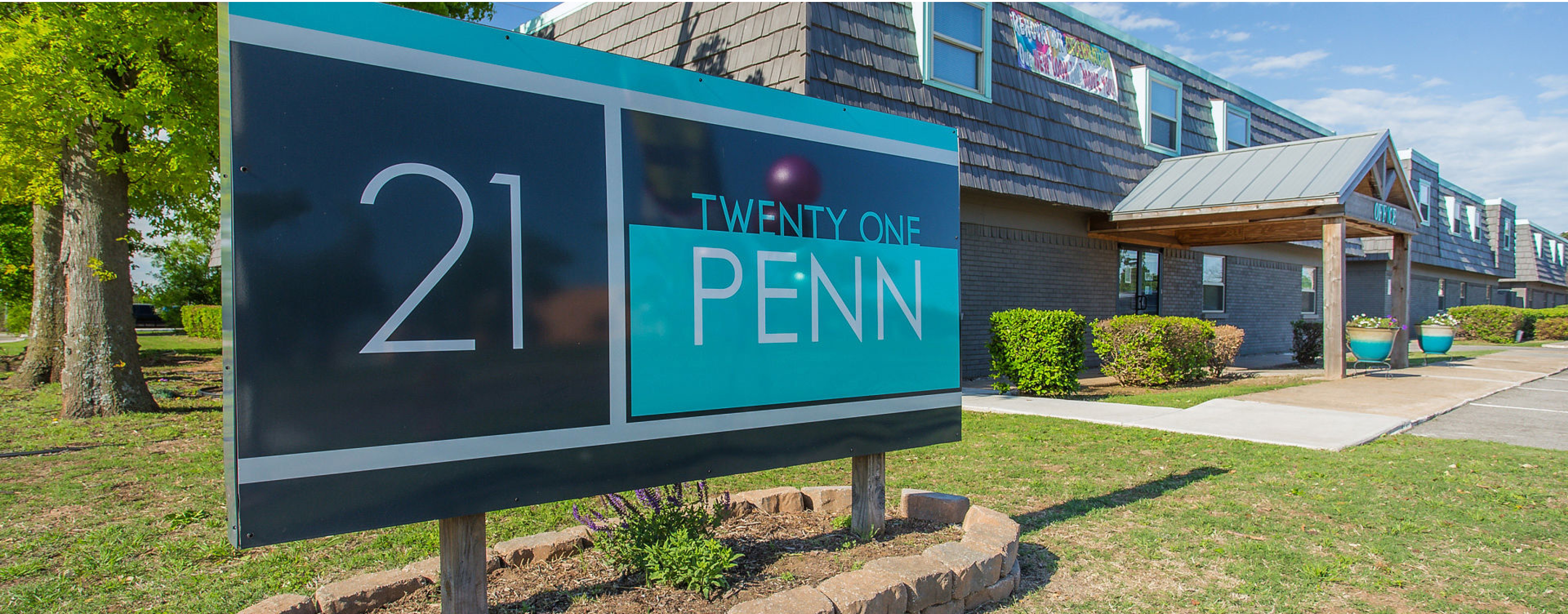 Signage for 21 Penn apartments with a building to the right.