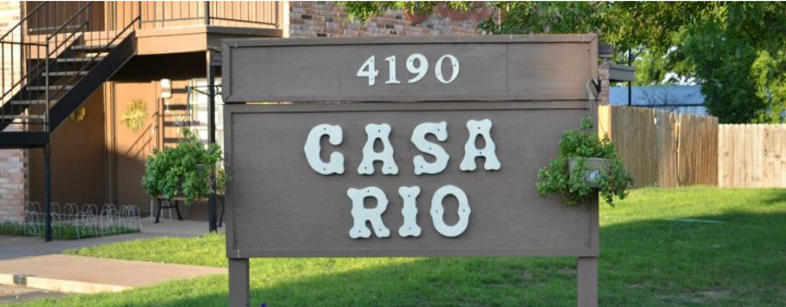 A zoomed-in photo of the Casa Rio sign with a partial view of the building in the back.