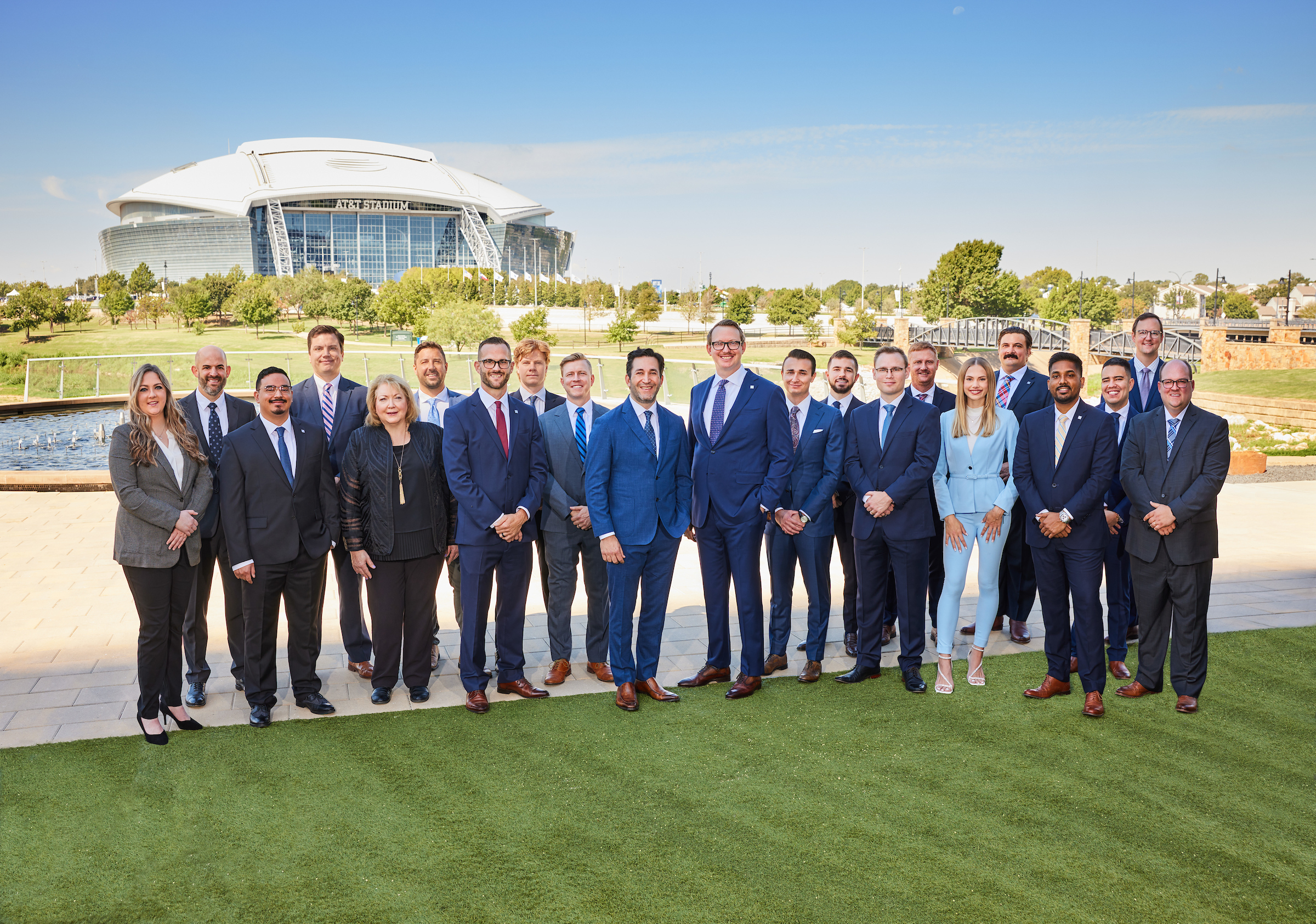 The team photo for The Multifamily Group taken in Arlington with the AT&T Stadium in the background.